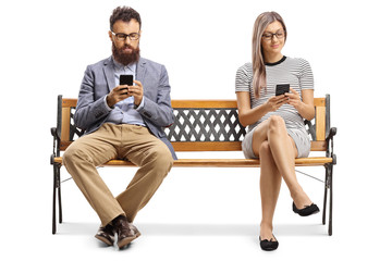 Wall Mural - Man and woman sitting on a bench and typiing on mobile phones