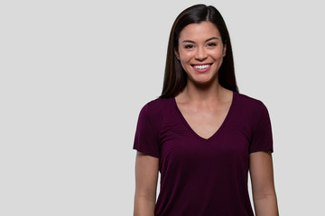 Commercial head shot advertising portrait of a pretty brunette woman with perfect white teeth, smiling with copy space 