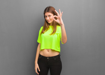 Young cool russian girl cheerful and confident doing ok gesture