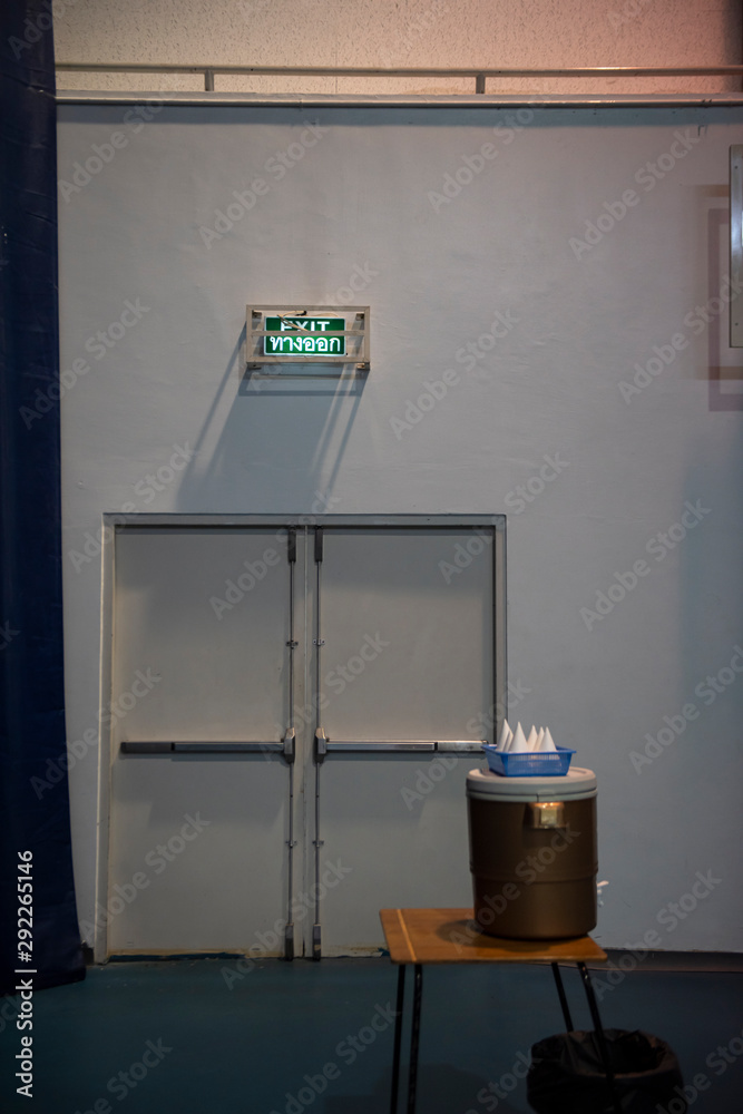 Emergency exit door in a sports pavilion with an Illuminated green ...