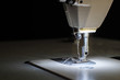 © Jedsada Naeprai - Close-up needle of white industrial sewing machine use sew cloth with black background.