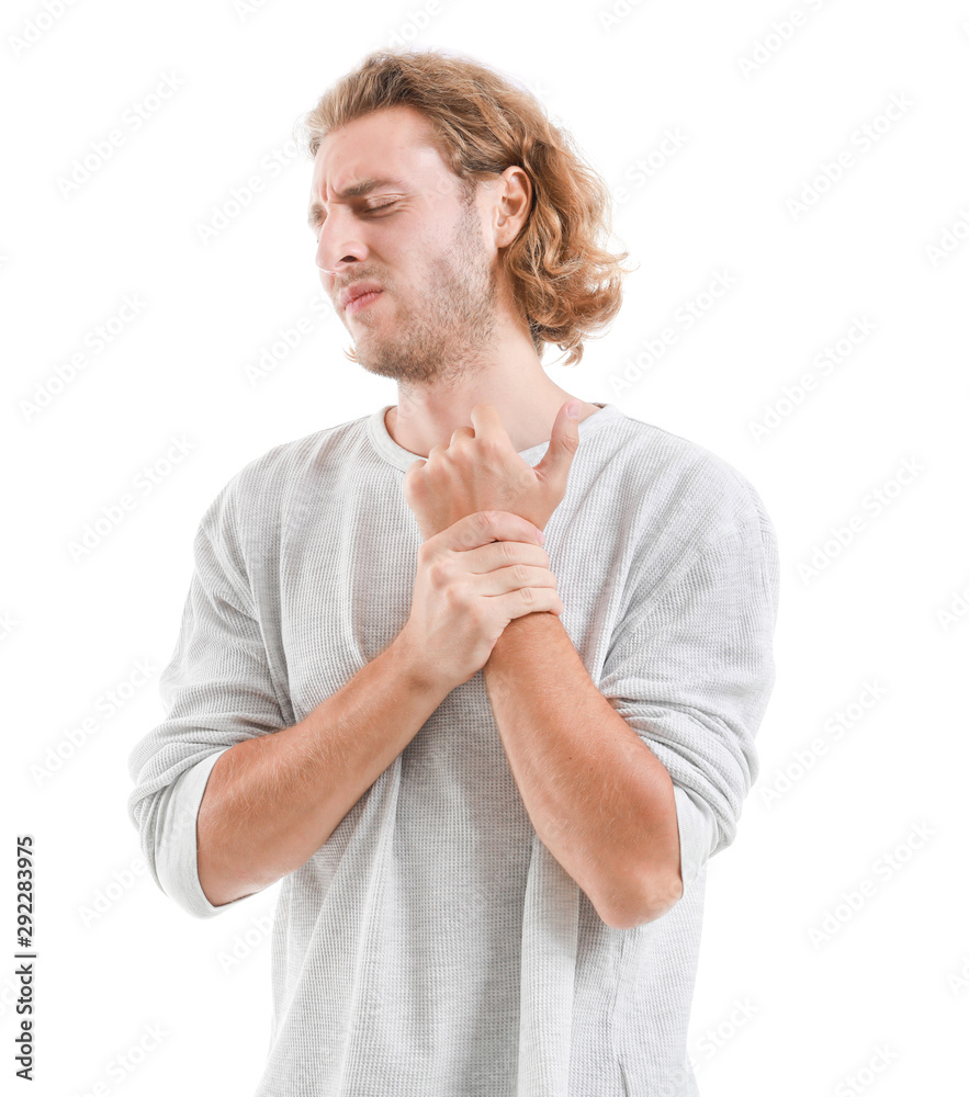 Young man suffering from pain in wrist on white background