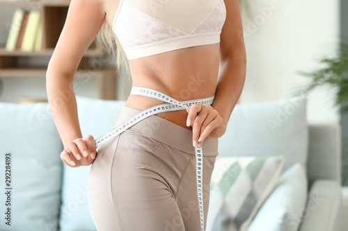Cuadros en Lienzo Beautiful young woman with measuring tape at home