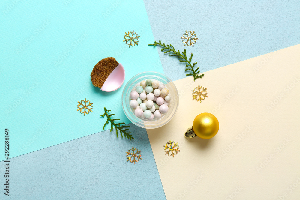 Powder pearls with brush and Christmas decor on color background