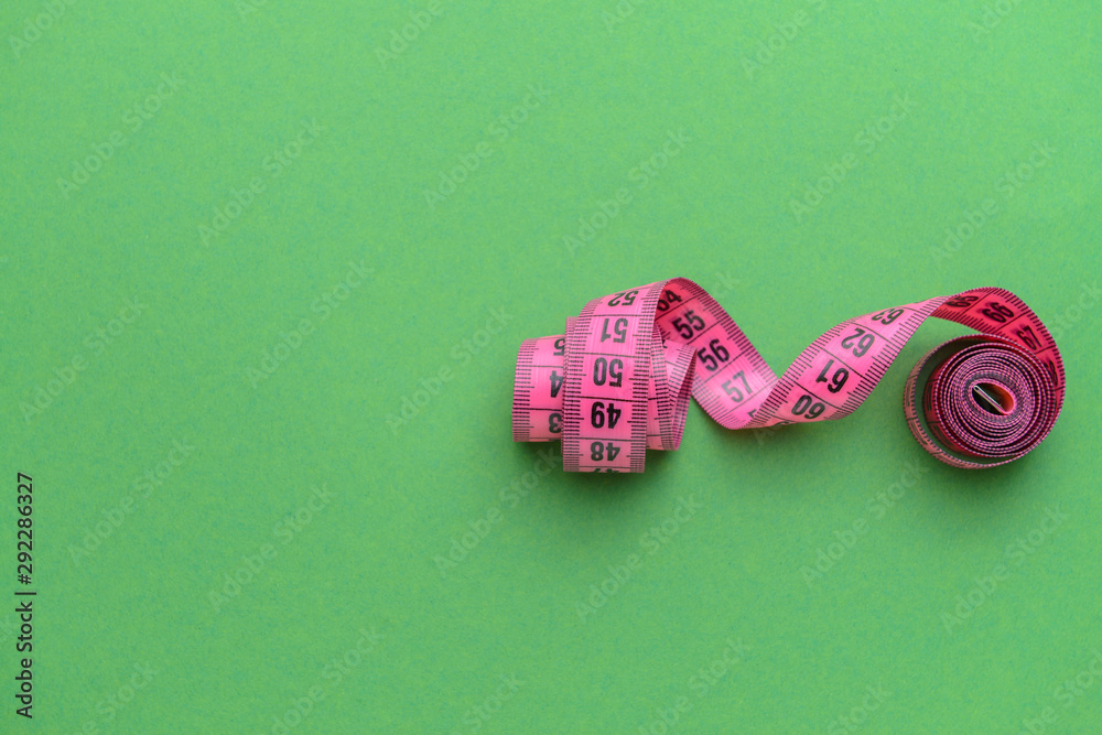 Measuring tape on color background