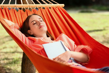 Sticker - Beautiful young woman with book resting in hammock outdoors