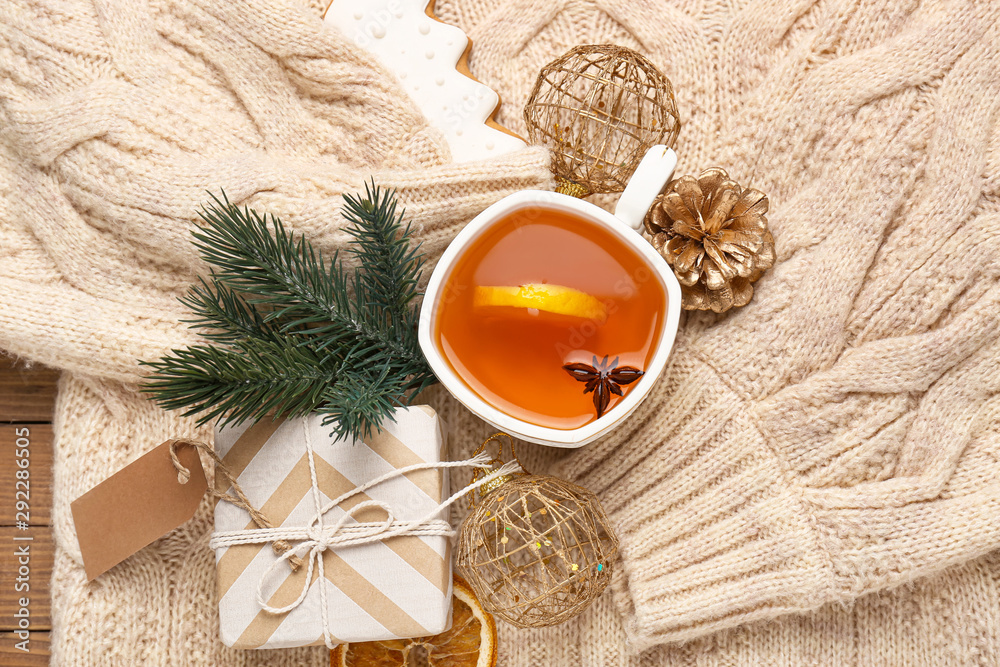 Cup of tea, Christmas gift and decor on warm sweater