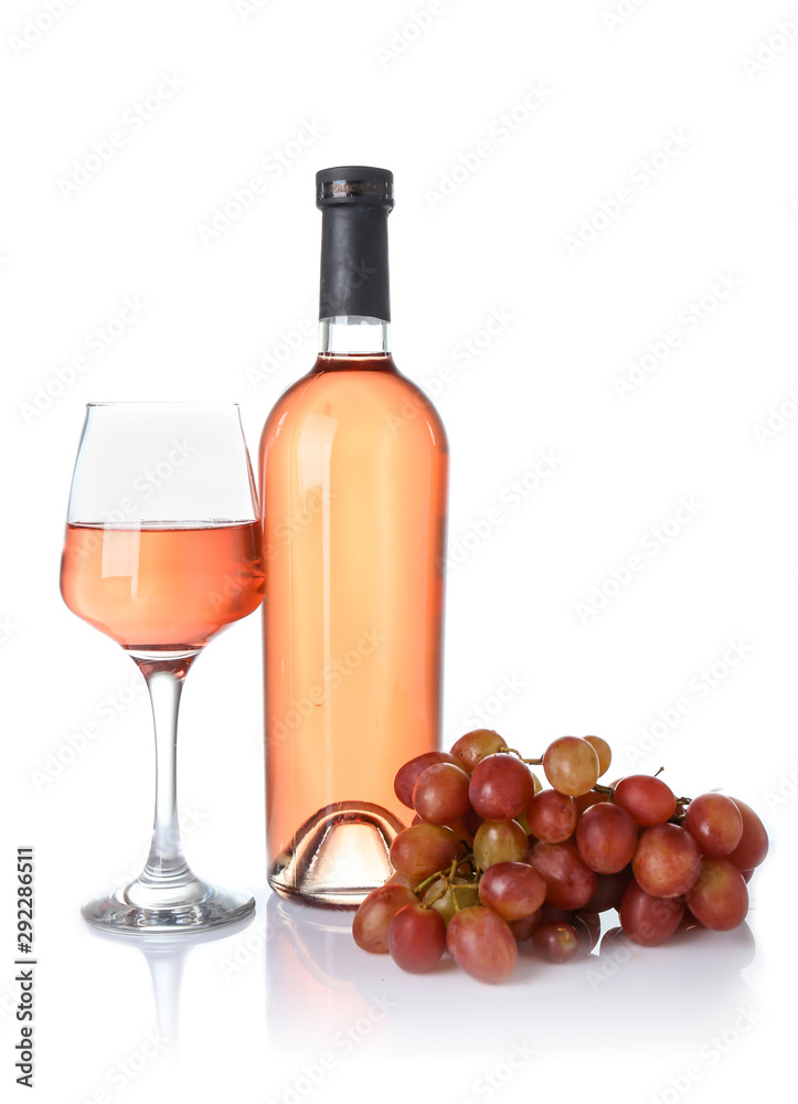 Glass and bottle of wine with grapes on white background
