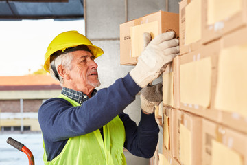 Wall Mural - Senior Arbeiter holt sich ein Paket aus dem Lager