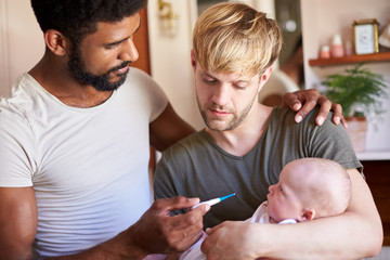 Wall Mural - Male Same Sex Couple Checking Baby Daughters Temperature In Bathroom At Home