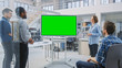 © Gorodenkoff - In the In Industrial Design Facility Team of Engineers and Technicians have a Meeting, Female Specialist Leads Briefing, Talks and Use Digital Interactive Whiteboard with Green Mock-up Screen
