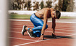 © iuricazac - Fit shirtless man preparing for running on racetrack at stadium. Sportsman, male runner sprinting during training session for competition. People, sport and healthy lifestyle