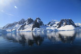 Fototapeta Sawanna - spokojne zimne wody pomiędzy ośnieżonych skałami u wybrzeży antarktydy w piękny słoneczny dzień