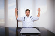 © GENETTICA - Front view of a scared young doctor with his hands up. Aggressions to doctors concept.