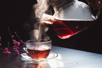 Wall Mural - The steam from a cup or a pot of coffee or tea on the black background, Warm drinks make good healthy, Selective focus.