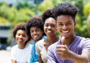 Wall Mural - African american young adult man with friends showing thumb up