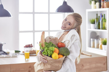 Young woman holding grocery shopping bag with vegetables Standi