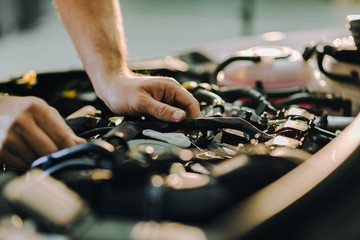 Close up of a mechanic analyzing car engine in a repair shop