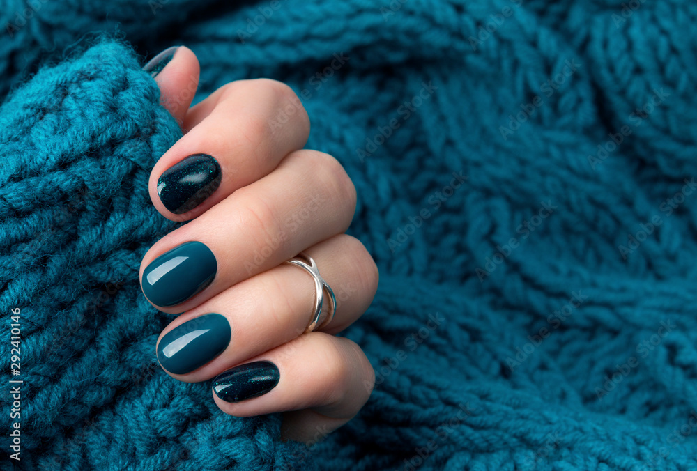 Foto Manicured woman's hand in warm wool turquoise sweater