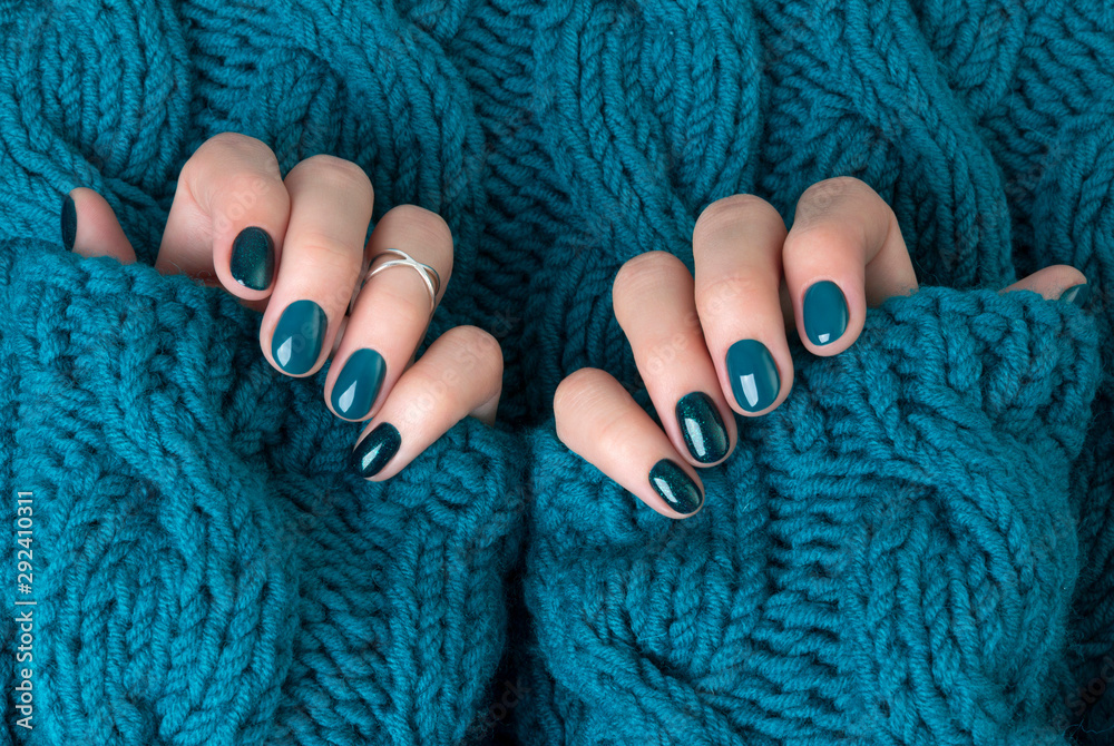 Fényképezés Manicured woman's hands in warm wool turquoise sweater
