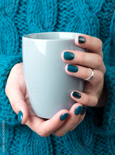 Woman's hands with turquoise manicure hold a grey cup of coffee or tea Tapéta, Fotótapéta