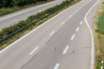 Driveway to a little German highway with tire tracks and damages