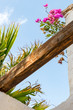 Blick auf einen Holzbalken auf einer Terrasse mit Bougainvillea und Palme auf Boavista, Kapverden