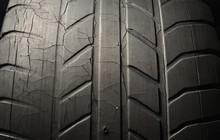 Old Black Tire With Worn Tread And Cracks, Worn Old Car Tire Tread, Old Damaged, Worn Black Tire Tread, Large Cracks In The Car Wheel, Tire Black Color For Background.