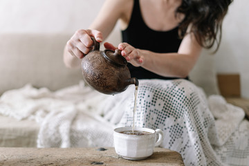 Wall Mural - Woman holding teapot and pouring tea in cup