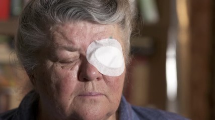 old woman with protective eye patch after cataract surgery.