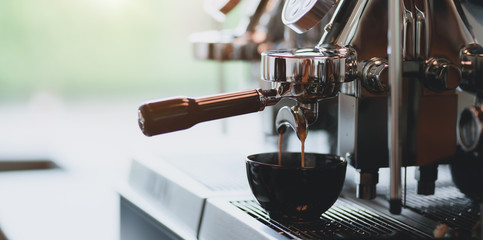 Close-up view of espresso pouring from espresso coffee machine into a coffee cup