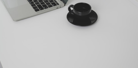 Top view of minimal workplace with laptop computer and coffee cup with copy spac