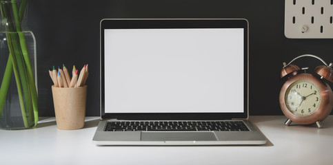 Fototapete - Open blank screen laptop with office supplies in dark trendy workplace on white table