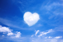 White Cloud In The Shape Of A Heart In The Blue Sky. Natural Shape Heart In The Sky With Clouds. Heart Shaped Cloud Over Blue Sky.