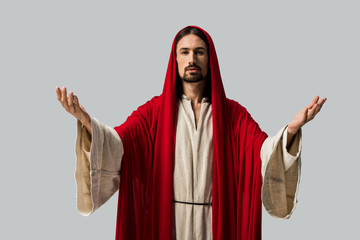 jesus in red hood with outstretched hands isolated on grey