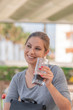 © JeanPaul - Nice young woman looking to one side while holding a glass of soda in one of her hands in a smiling manner with the background out of focus.