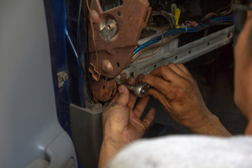 close up hands mechanic fixing car with wrench in garage.