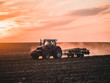 Tractor on filed by sunset.