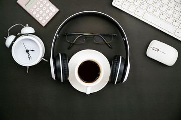 Wall Mural - Office desk business objects of white coffee cup,keyboard,headphone,white alarm clock,calculator,mouse and glasses on blackboard