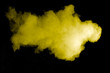Yellow color powder explosion on black background.