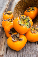 Wall Mural - Persimmon on wood table. Tropical fruit.