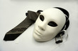 Theater or misogyny concept. Closeup of white classical theatrical mask and men clothing items as a symbol of sexual abuse or masculinity.