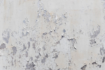 Grunge white metal wall with peeling paint, close-up background photo texture