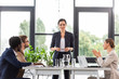 © LIGHTFIELD STUDIOS - multiethnic businesspeople sitting at tables during conference in office