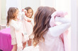 © Elena - shopping. vertical photo. discounts. little girl shopaholic. girl trying on a beautiful dress gently pink in the fitting room of the boutique. shopping center, shopping. emotions