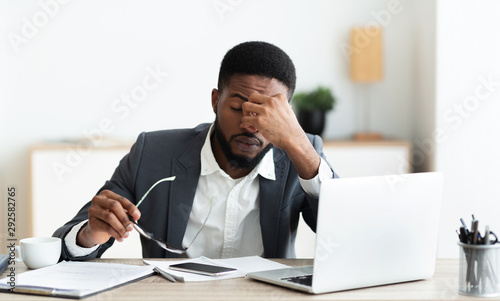 Cuadros en Lienzo Overworked businessman sitting at workplace after hard day in office