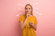Blonde girl thinks about the right option. Confused and pensive expression. Pink background