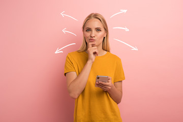 blonde girl thinks about the right option. confused and pensive expression. pink background