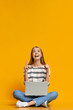 © Prostock-studio - Excited teen girl with laptop pointing upwards at free space