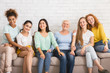 © Prostock-studio - Group Of Women Smiling Sitting On Couch Against White Wall